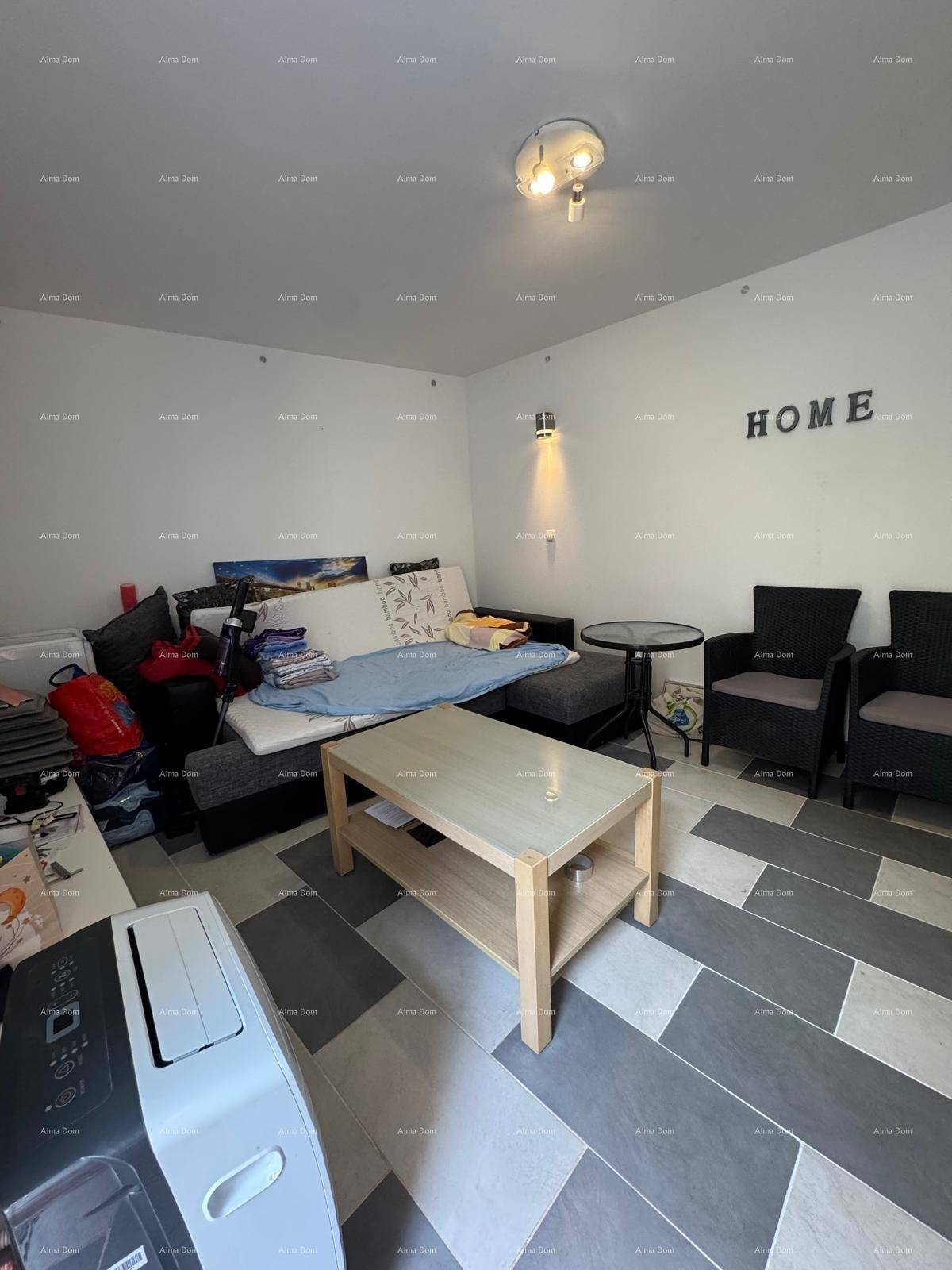 Wohnbereich mit Sofa, Couchtisch und zwei Sesseln, mit dekorativem Schriftzug an der Wand.