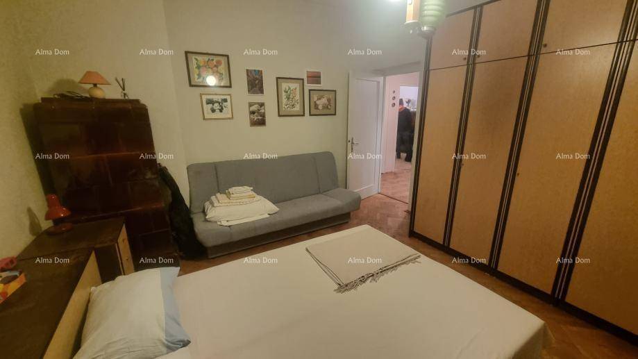 Schlafzimmer mit einem Bett, einem Sofa und geräumigen Kleiderschränken, die viel Stauraum bieten.
