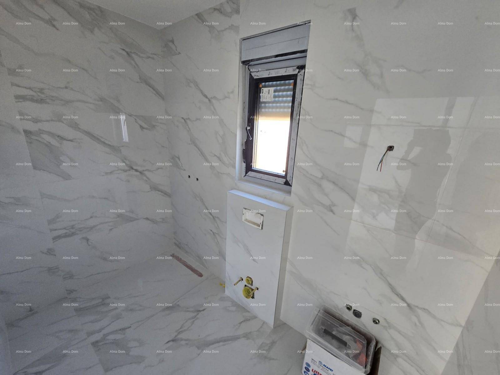 Modernes Badezimmer im Rohbau mit großformatigen Marmorfliesen und Fenster für Tageslicht.