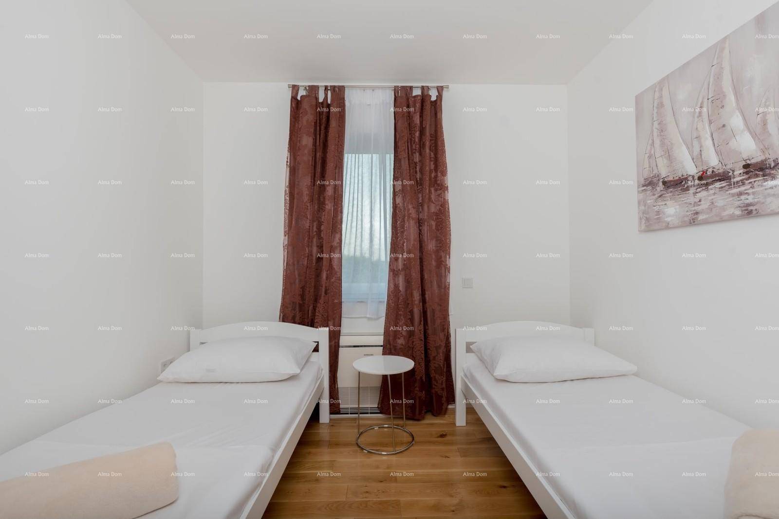 Helles Schlafzimmer mit zwei Einzelbetten, Holzboden und Fenster.