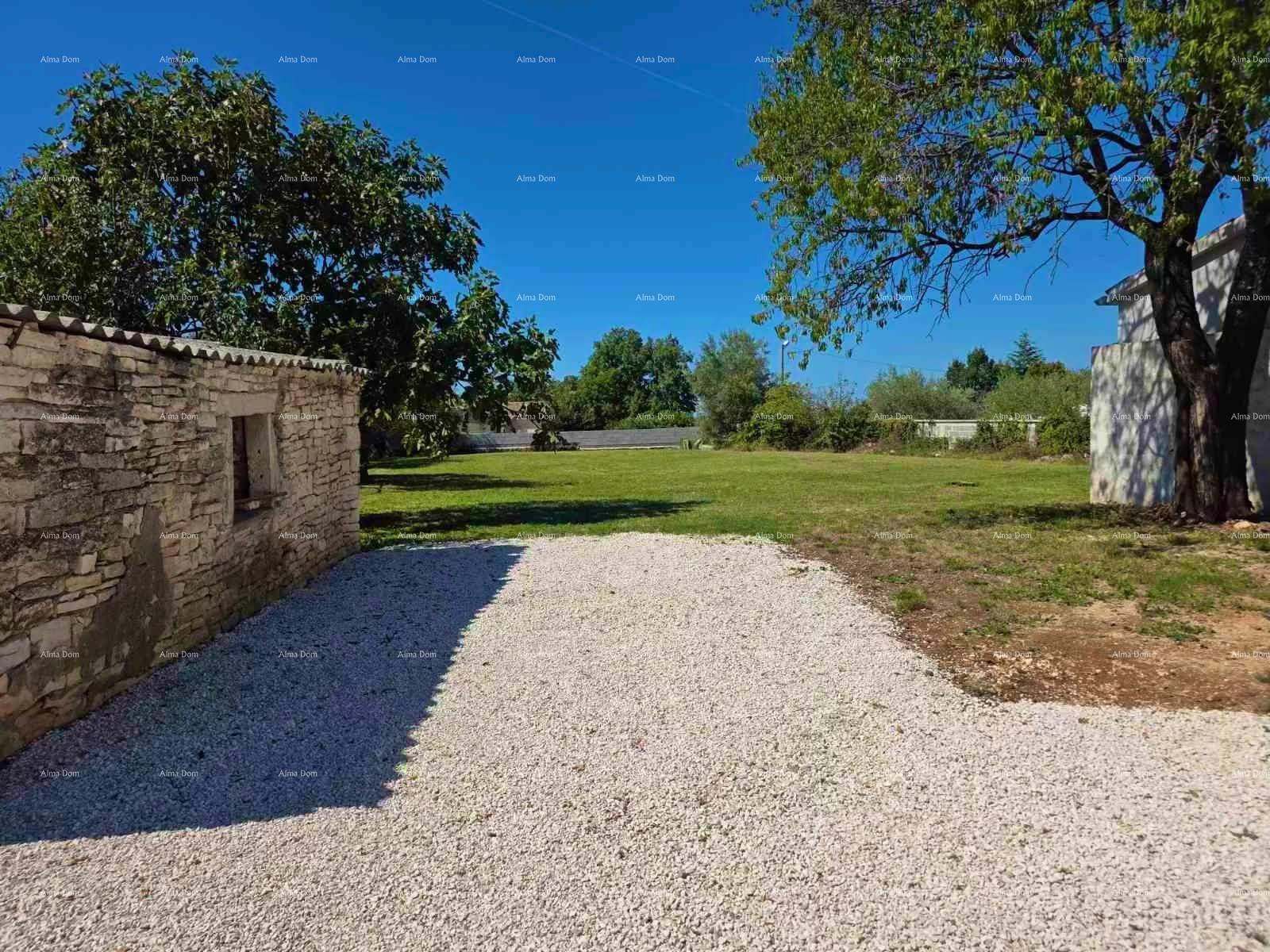 Großer Gartenbereich mit Rasenfläche, Bäumen und einem kleinen Nebengebäude aus Stein.