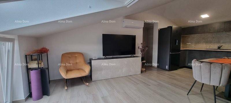 Offener Wohnbereich mit Fernseher, Schaukelstuhl und Klimaanlage.