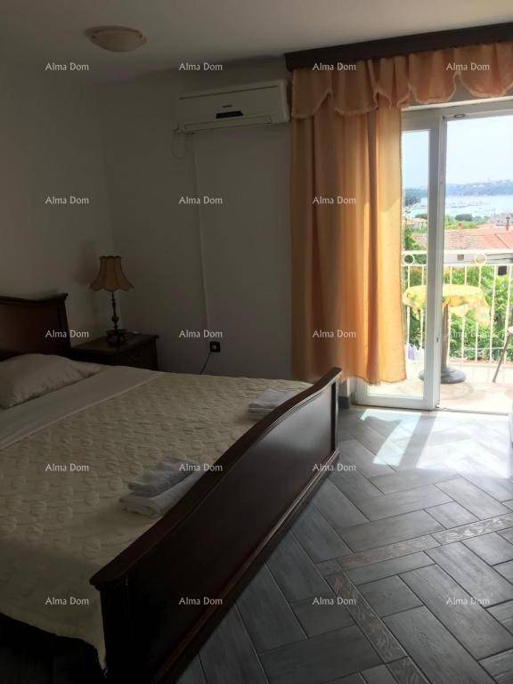 Schlafzimmer mit Doppelbett, Klimaanlage und Zugang zu einem Balkon mit Meerblick.