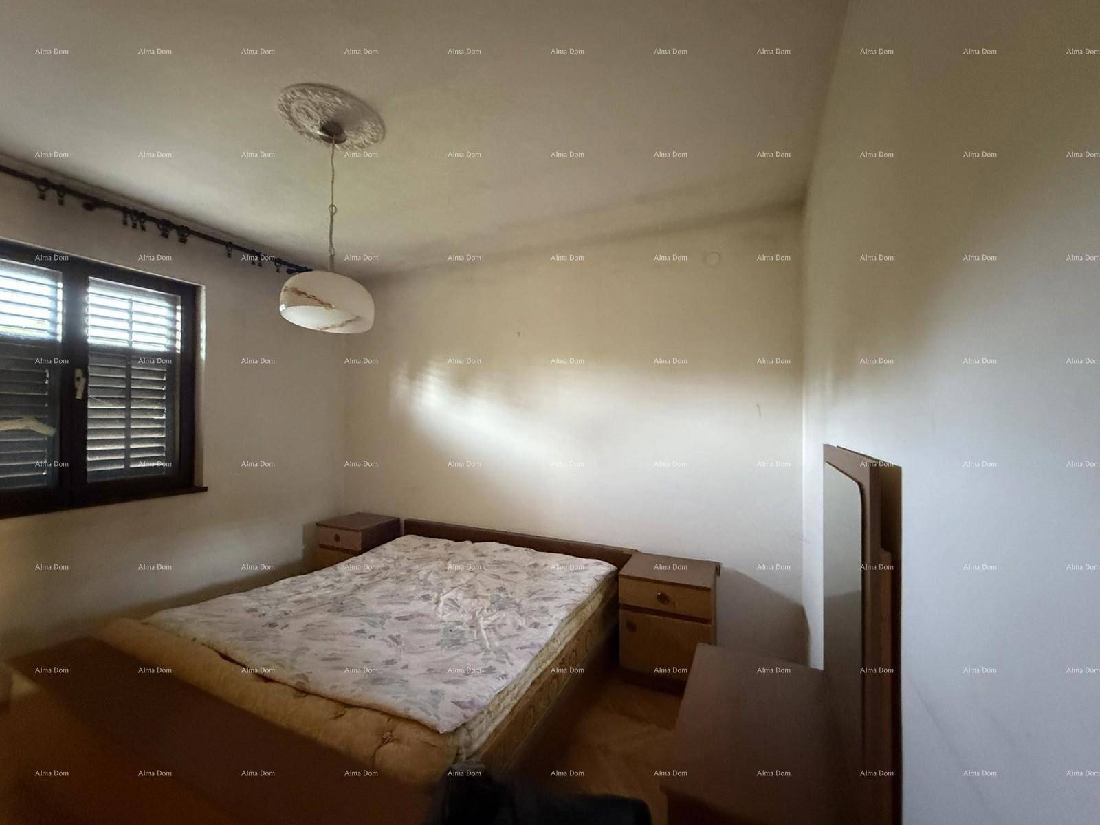 Schlafzimmer mit Doppelbett, Nachttischen und Fenster mit Fensterläden.