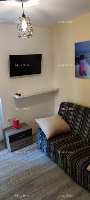 Gemütliches Wohnzimmer mit Sofa, Wandfernseher und moderner Hängelampe.