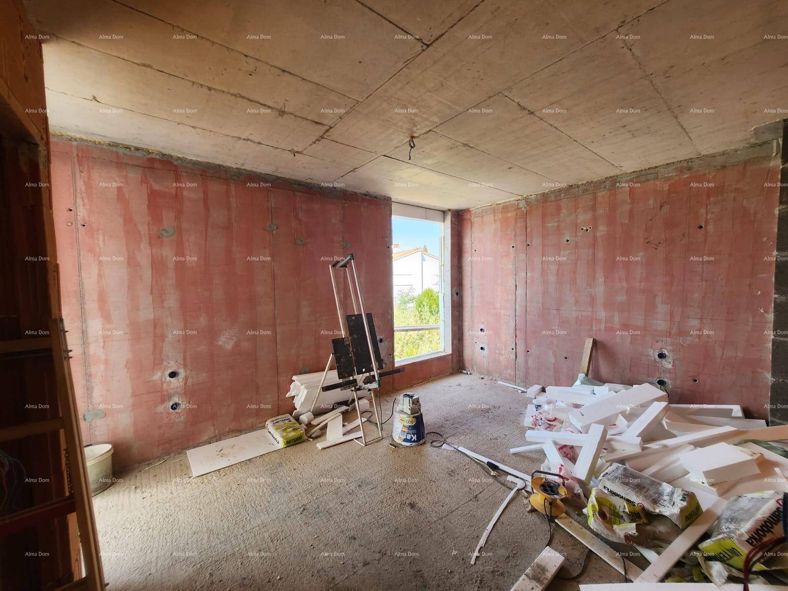 Rohbau eines Raumes mit unverputzten Wänden, Betonboden und einem Fenster mit Blick nach draußen.