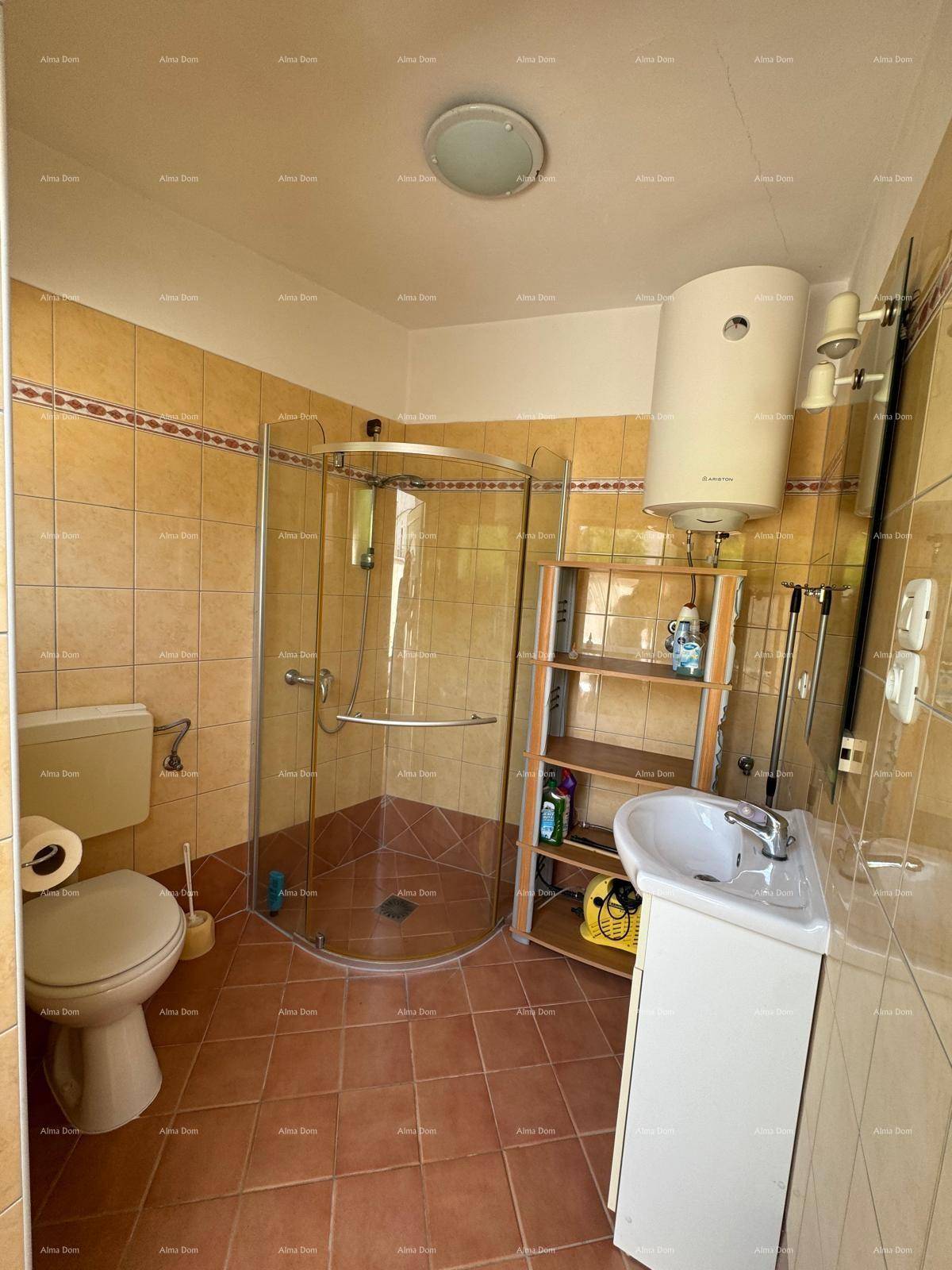 Badezimmer mit braunen Fliesen, Duschkabine, Toilette und Waschbecken, funktional eingerichtet.