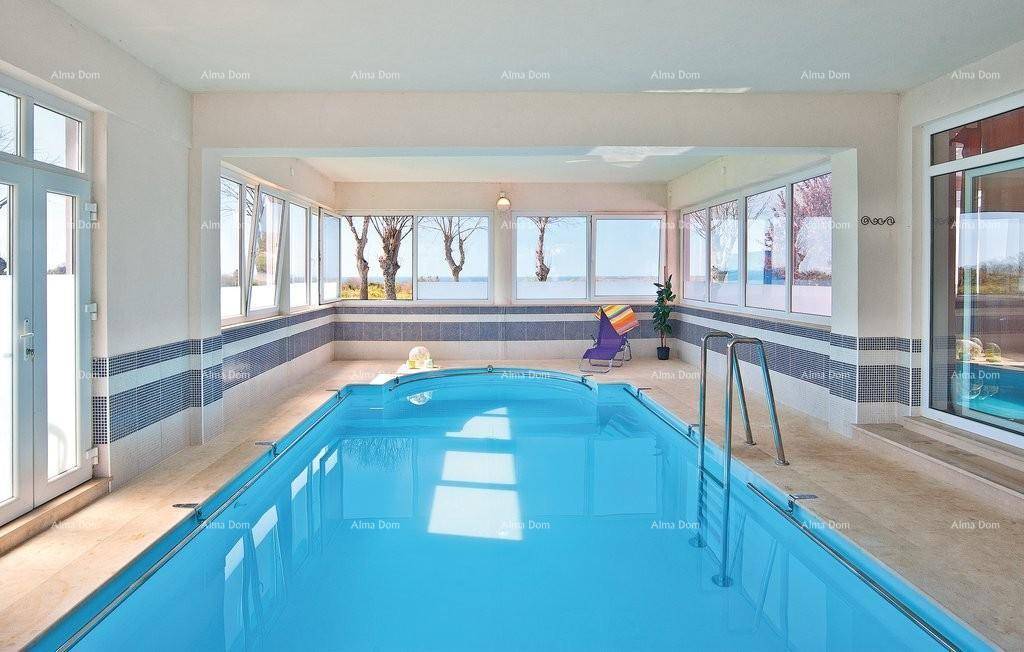 Innenpoolbereich mit großen Fenstern und Liegestühlen für Entspannung.
