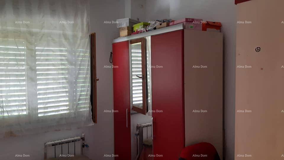 Schlafzimmer mit farbenfrohem rot-weißem Kleiderschrank und Fenster mit Jalousien für Privatsphäre.