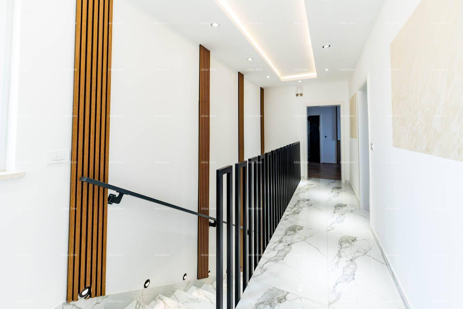 Heller Flur mit moderner Treppe, Holzvertäfelung und indirekter Deckenbeleuchtung.