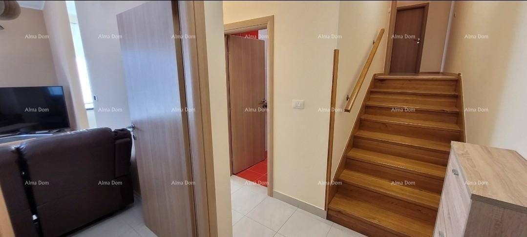 Heller Flur mit Holztreppe, die zu den oberen Etagen führt.