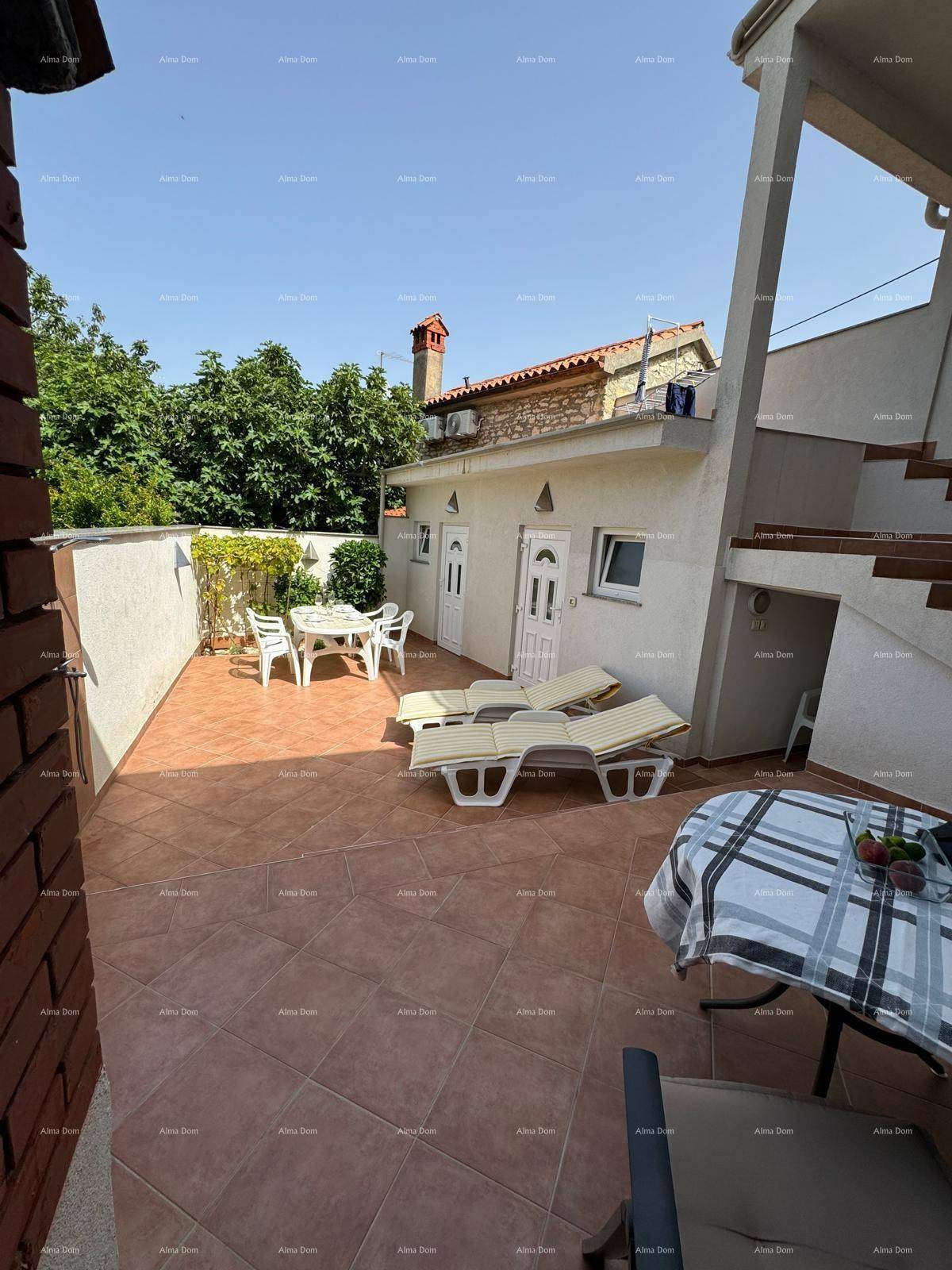 Sonniger Terrassenbereich mit Liegestühlen und Esstisch, umgeben von mediterraner Vegetation.