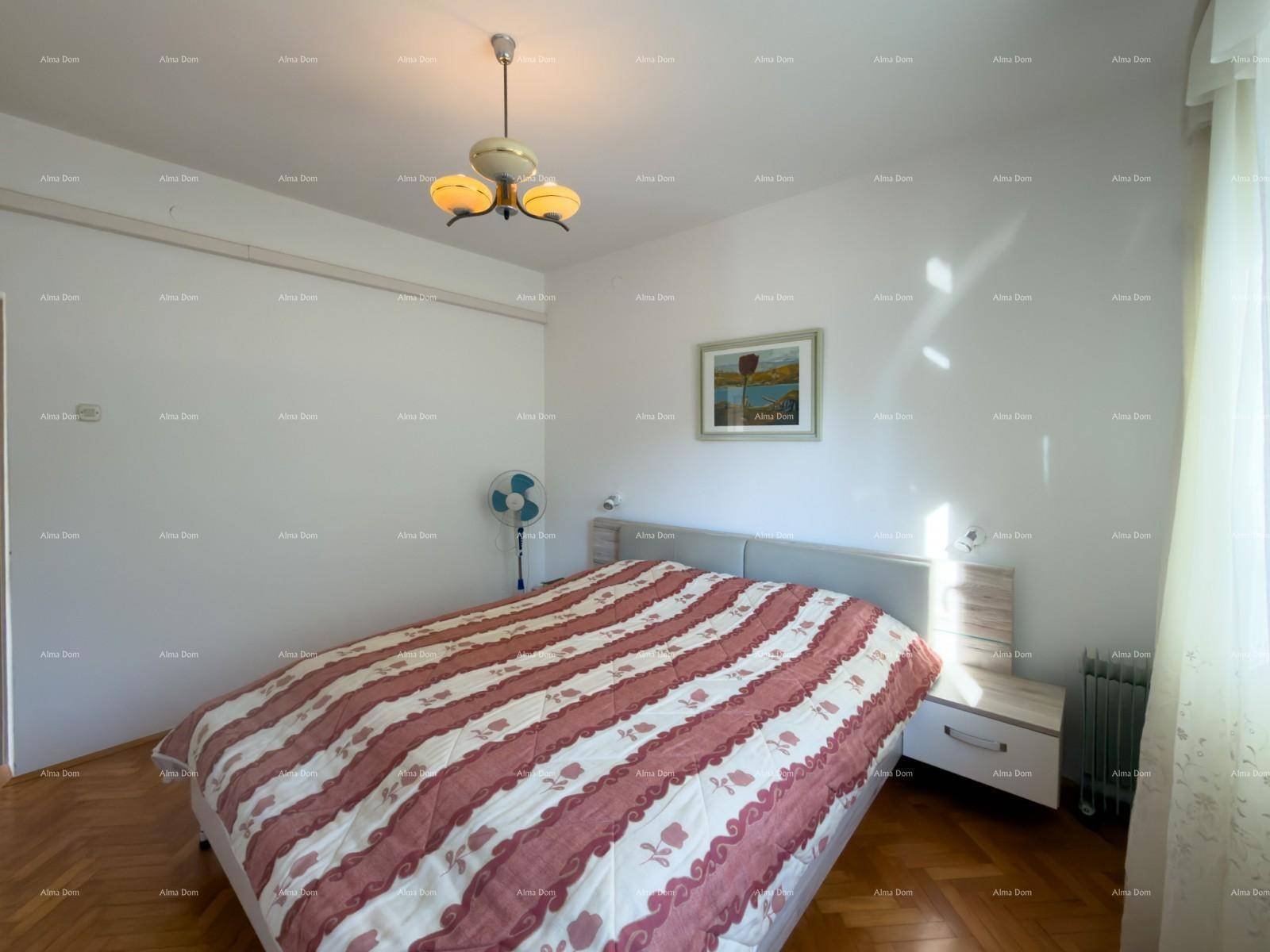 Schlafzimmer mit Doppelbett, Parkettboden und heller Wandgestaltung, gut beleuchtet.