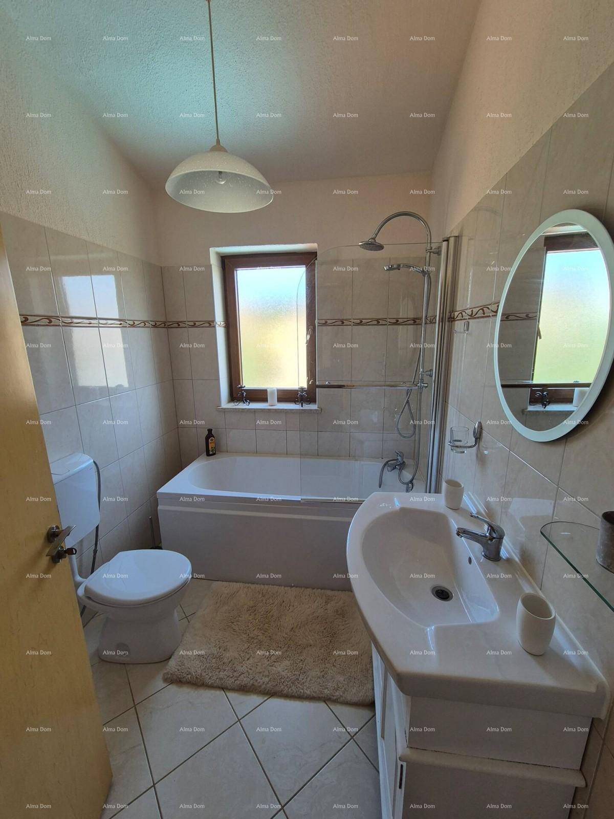 Helles Badezimmer mit Badewanne, Dusche, WC und Fenster, ausgestattet mit beigen Fliesen.