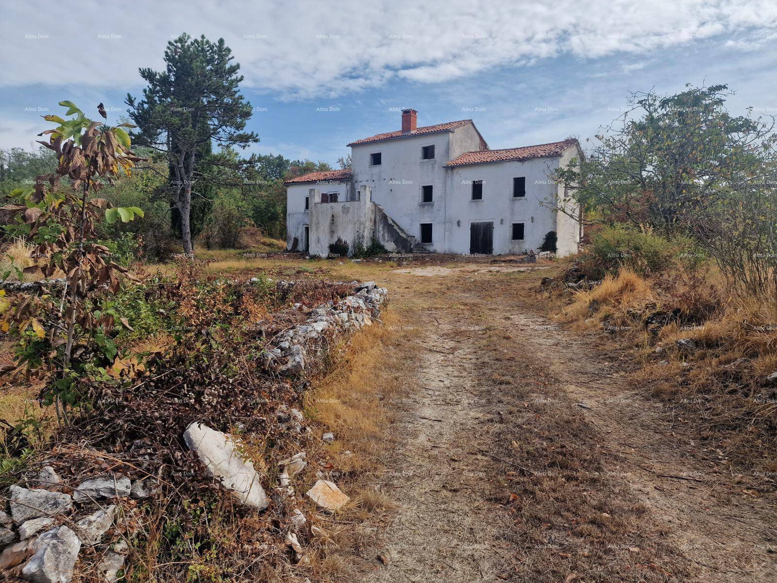 Traditionelles Gebäude in ländlicher Umgebung mit unfertigem Außenbereich und einem Feldweg.