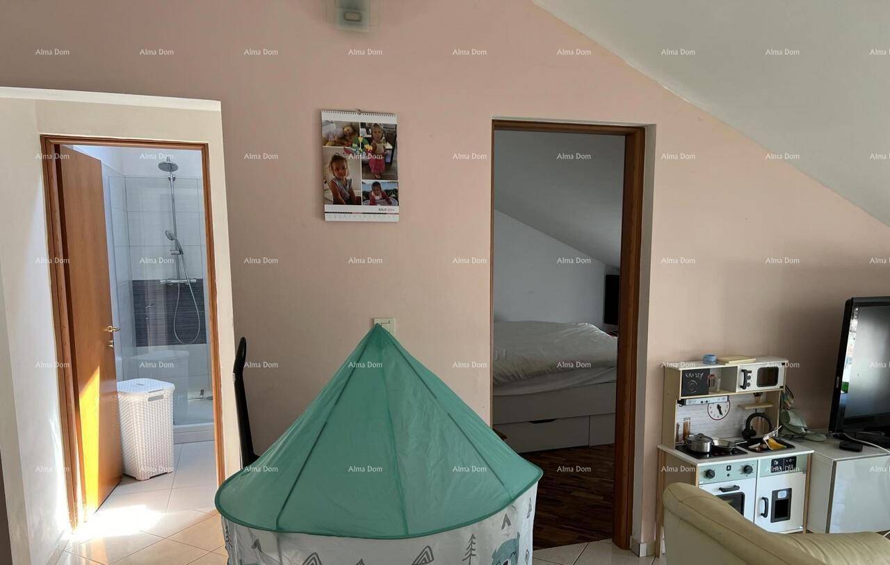 Flur im Dachgeschoss mit Zugang zu Badezimmer und Schlafzimmer, ausgestattet mit Spielbereich für Kinder.
