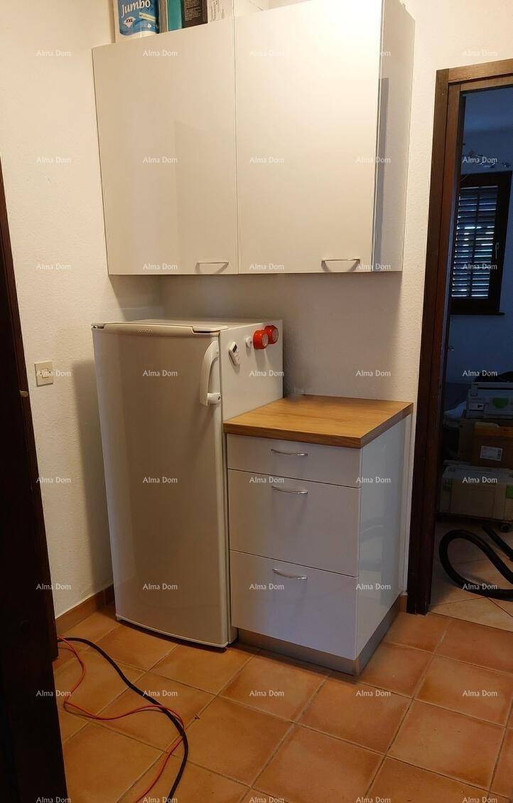 Küchenbereich mit einem Kühlschrank, Unterschränken und passenden Hängeschränken.