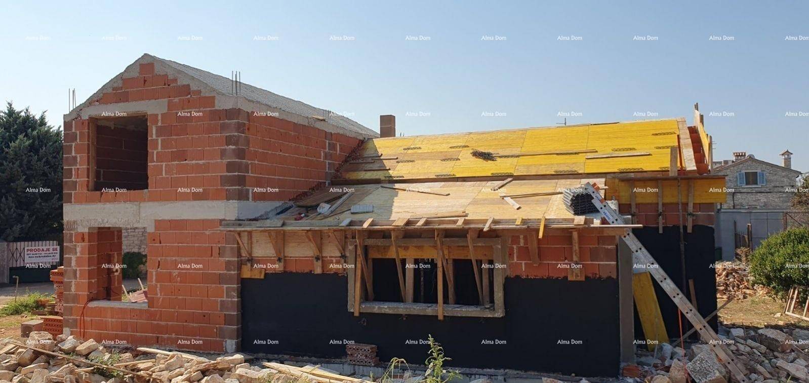 Haus im Rohbau mit Ziegelwänden und sichtbarer Holzkonstruktion des Daches.