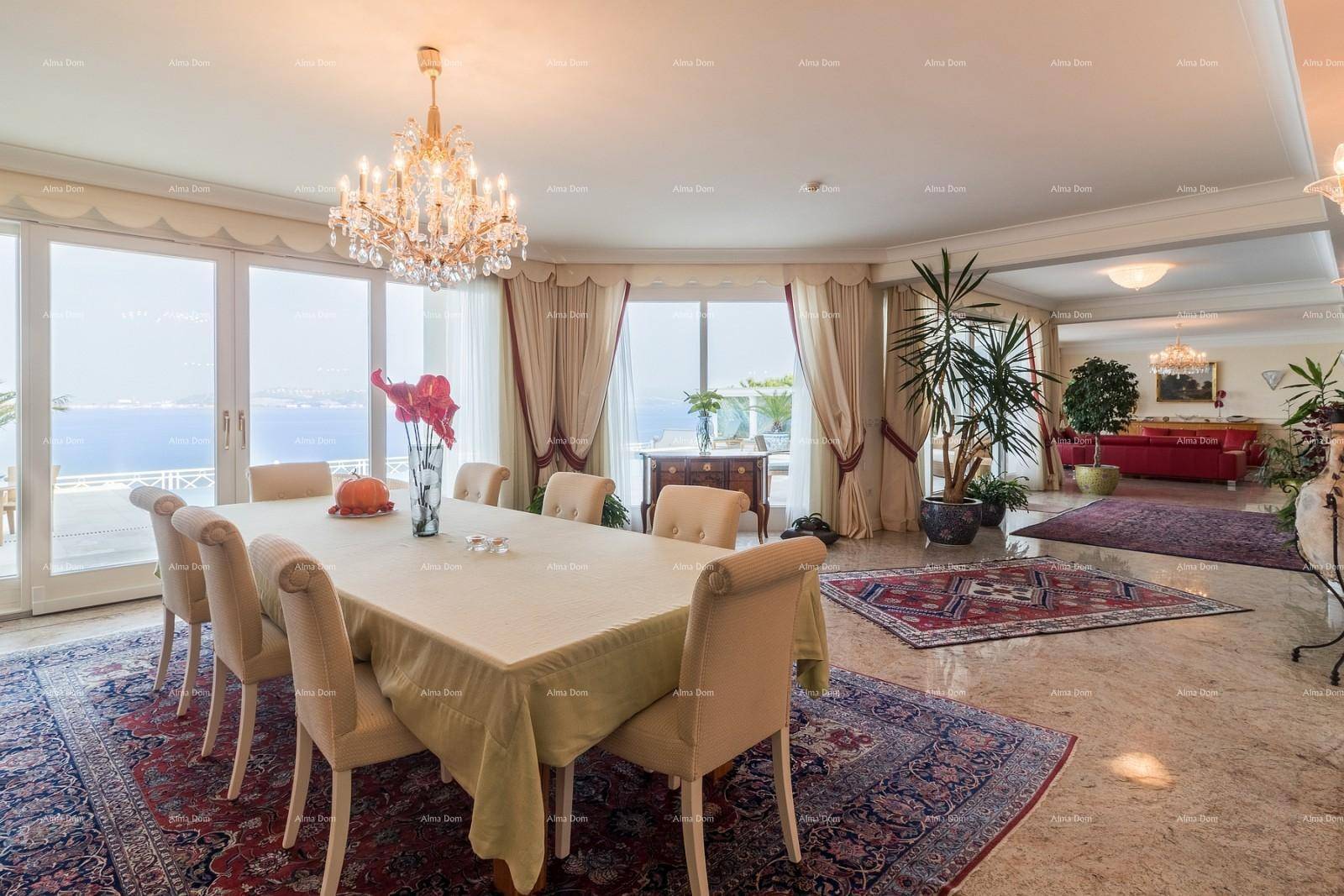 Heller Essbereich mit Meerblick, großem Esstisch und elegantem Kronleuchter.