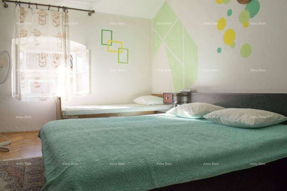 Schlafzimmer mit Doppelbett, Einzelbett und farbigen Wanddekorationen.