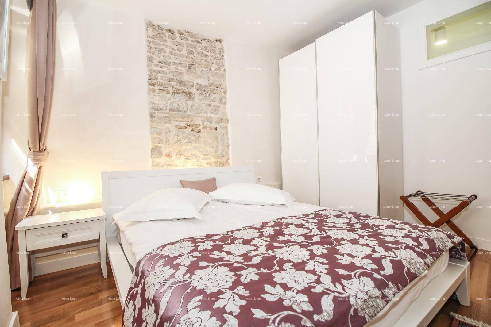 Schlafzimmer mit Doppelbett, Holzboden und einer markanten Steinwand, die einen besonderen Akzent setzt.