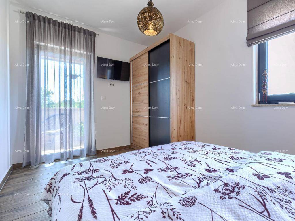 Helles Schlafzimmer mit Holzboden, großem Fenster und Zugang zu einem Außenbereich.