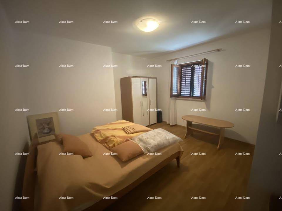 Gemütliches Schlafzimmer mit Einzelbett, Kleiderschrank und Fenster mit Fensterläden.
