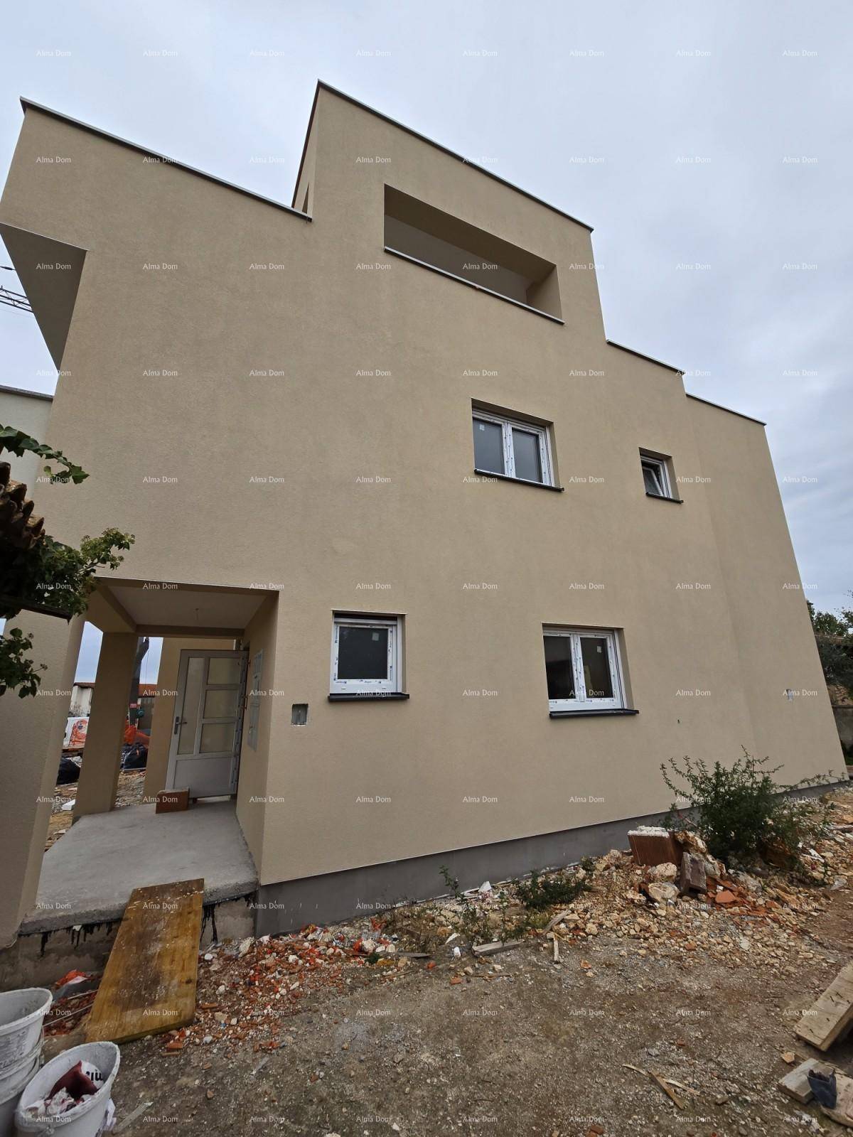 Moderne Fassade eines Neubaus mit klaren Linien und einfacher Gestaltung, umgeben von Baustellenmaterial.