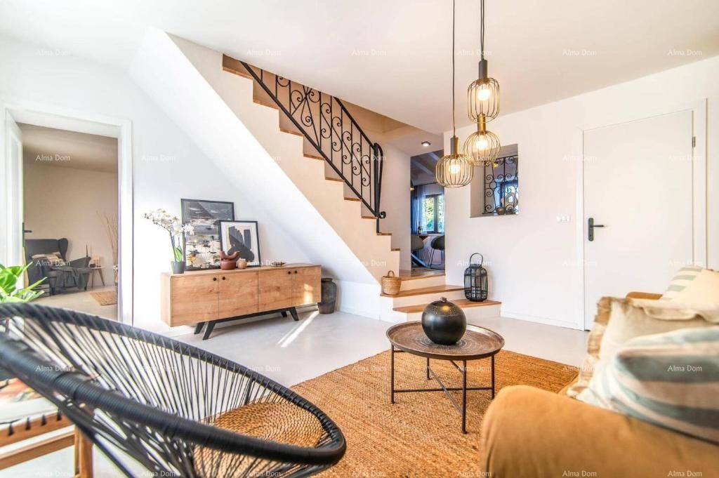 Helles Wohnzimmer mit moderner Einrichtung, Holzkommode und Treppe, die in die obere Etage führt.