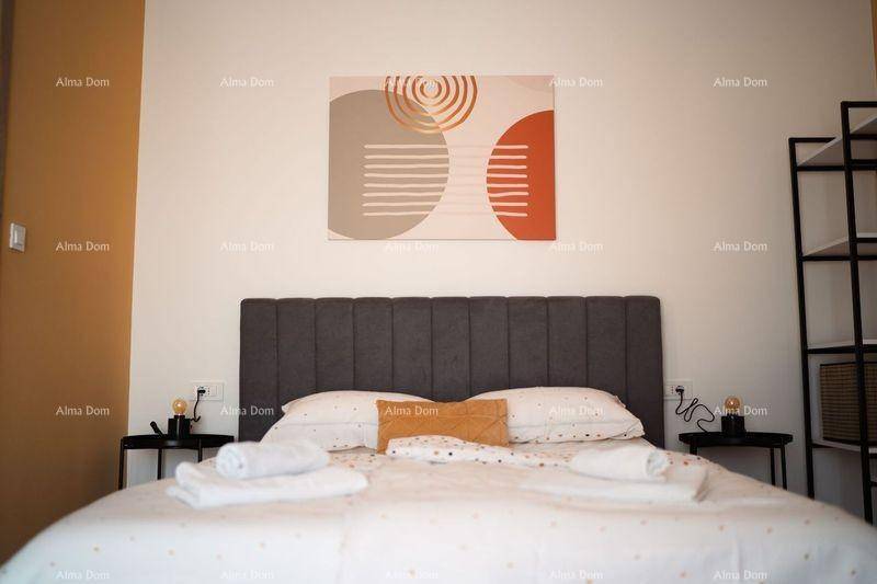 Detailansicht des Bettes mit Kunstwerk über dem Kopfteil und gelber Akzentwand.