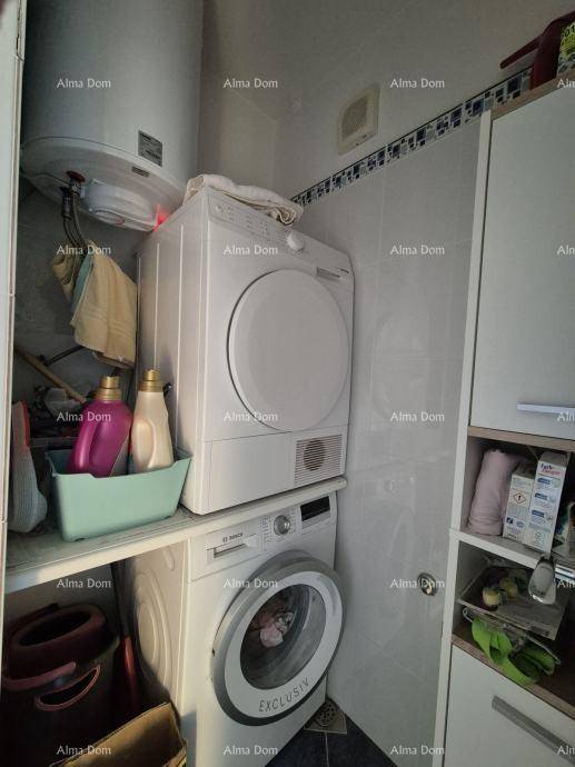 Praktischer Hauswirtschaftsraum mit Waschmaschine, Trockner und Warmwasserboiler.