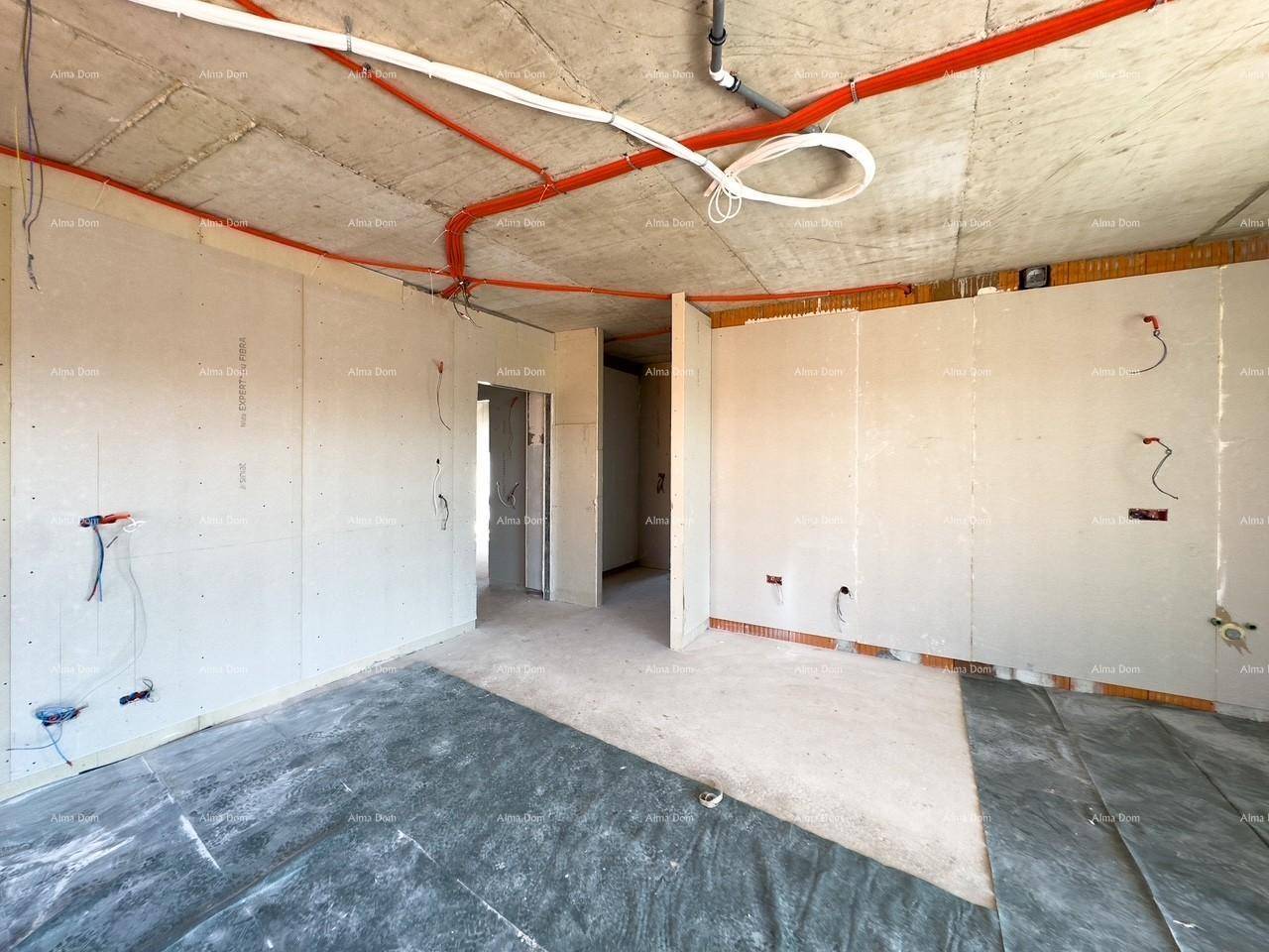 Rohbau eines Raumes mit vorbereiteten Wänden, sichtbaren Leitungen und Zugang zu anderen Bereichen.