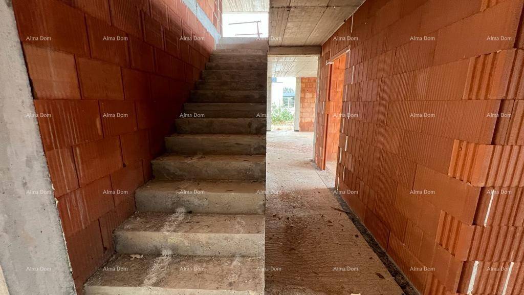Unfertige Betontreppe und Ziegelwände im Inneren des Rohbaus.