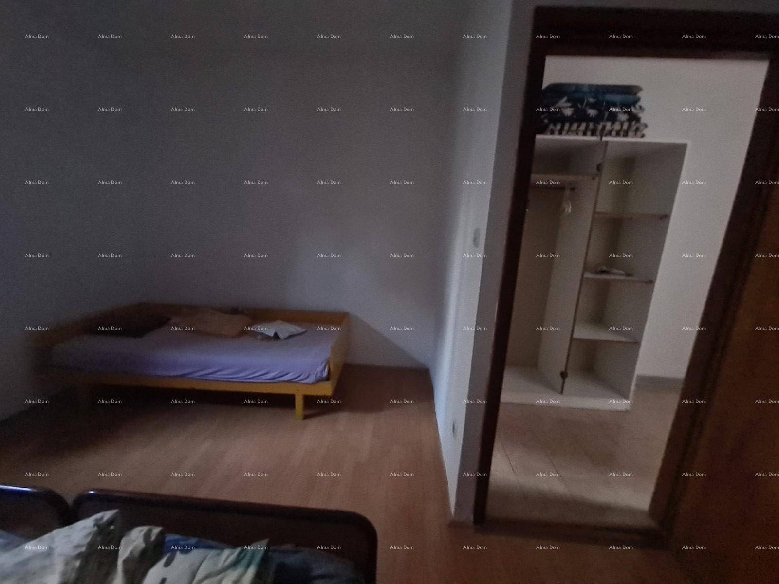 Schlafzimmer mit Einzelbett und großem Spiegelschrank, heller Holzboden.