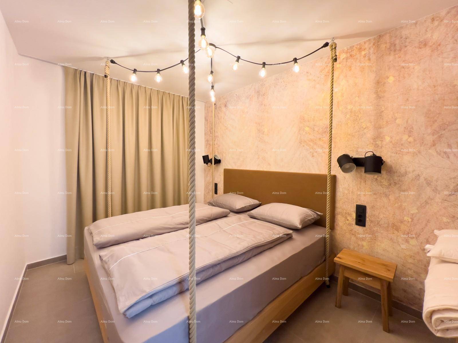 Schlafzimmer mit Doppelbett, dekorativer Wandgestaltung und Lichterkette als einzigartige Deckenbeleuchtung.