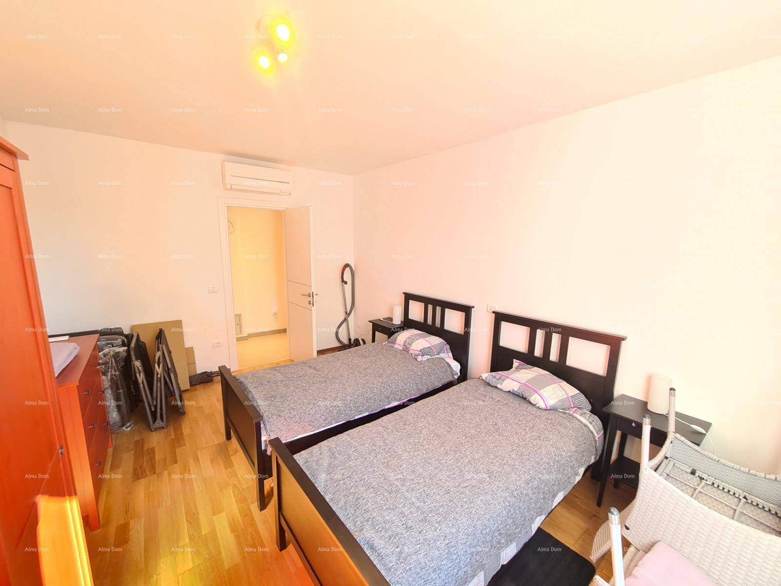 Helles Schlafzimmer mit zwei Betten, Holzparkett und Klimaanlage.