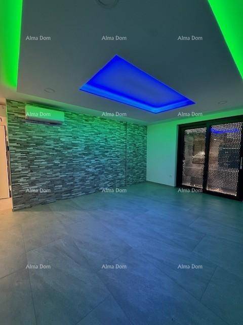 Moderner Wohnraum mit farbiger LED-Deckenbeleuchtung, Steinwandakzent und Zugang zum Außenbereich.