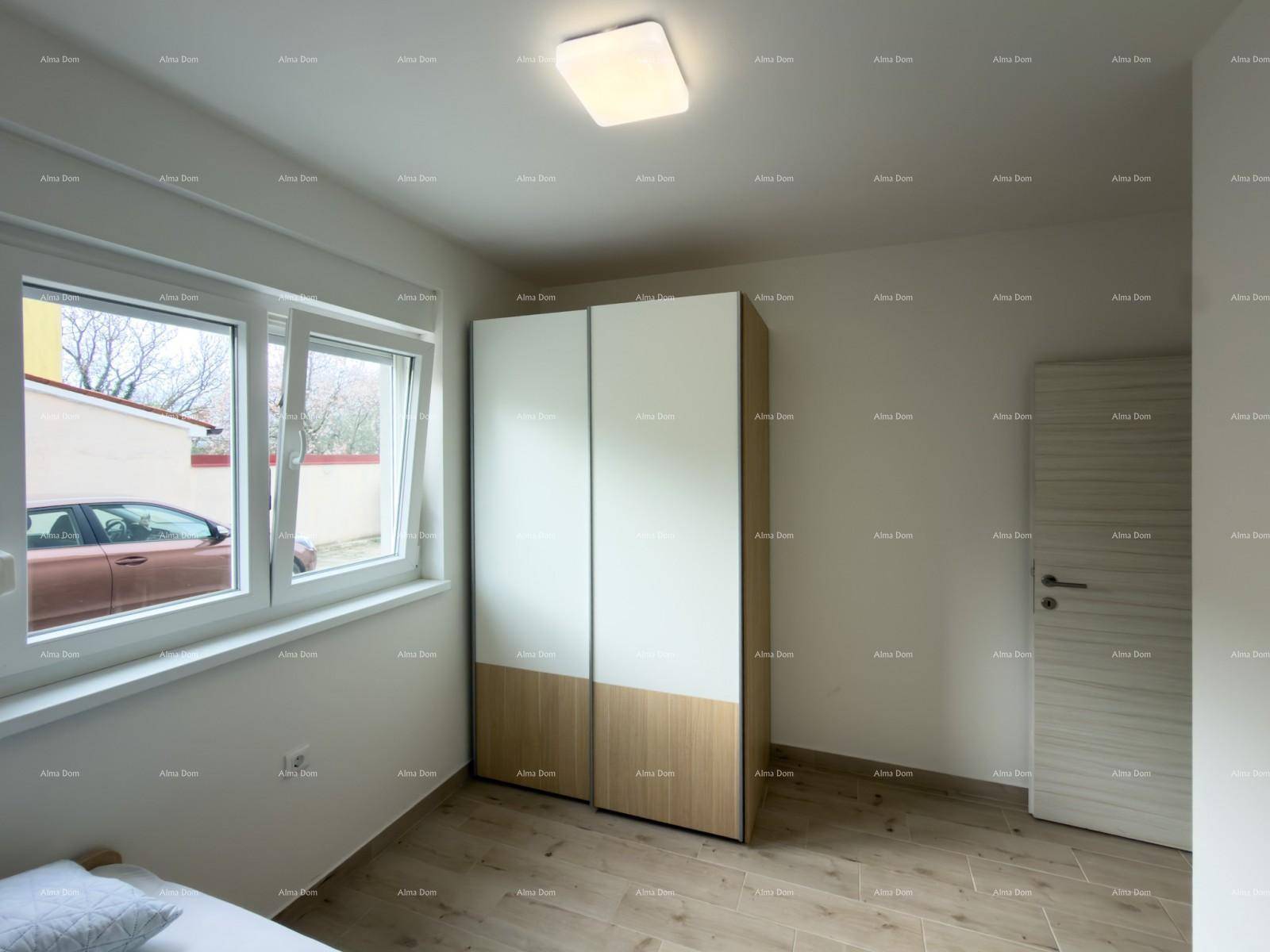 Helles Schlafzimmer mit Fenster, modernem Kleiderschrank und Laminatboden.