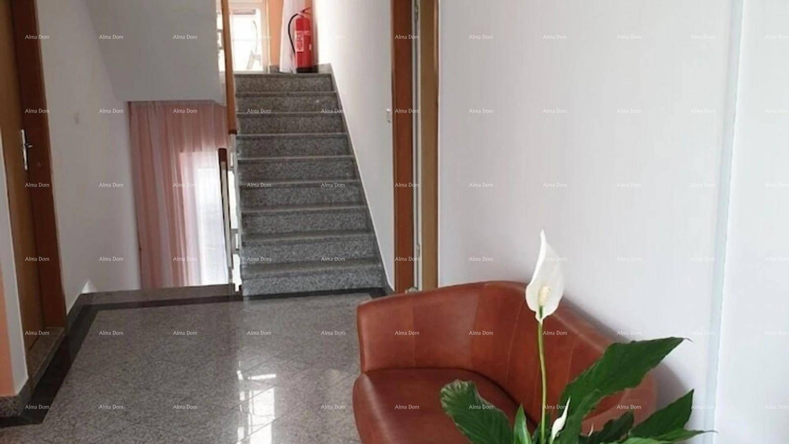 Heller Flur mit Granitboden, einer Ledercouch und einer Treppe, die in die oberen Etagen führt.