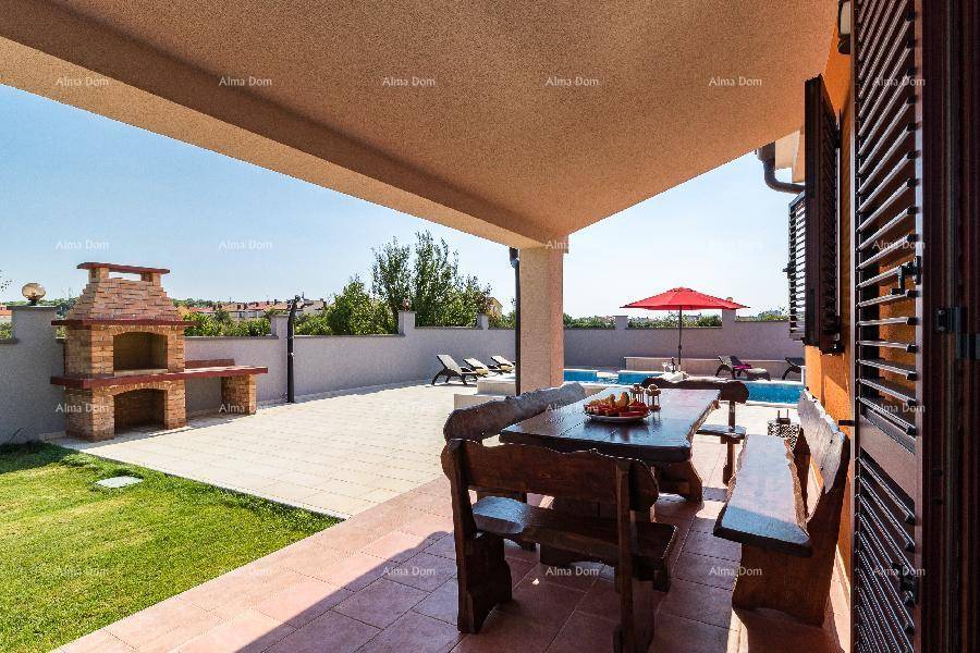 Geräumige überdachte Terrasse mit Esstisch, Grillplatz und Zugang zum Poolbereich.