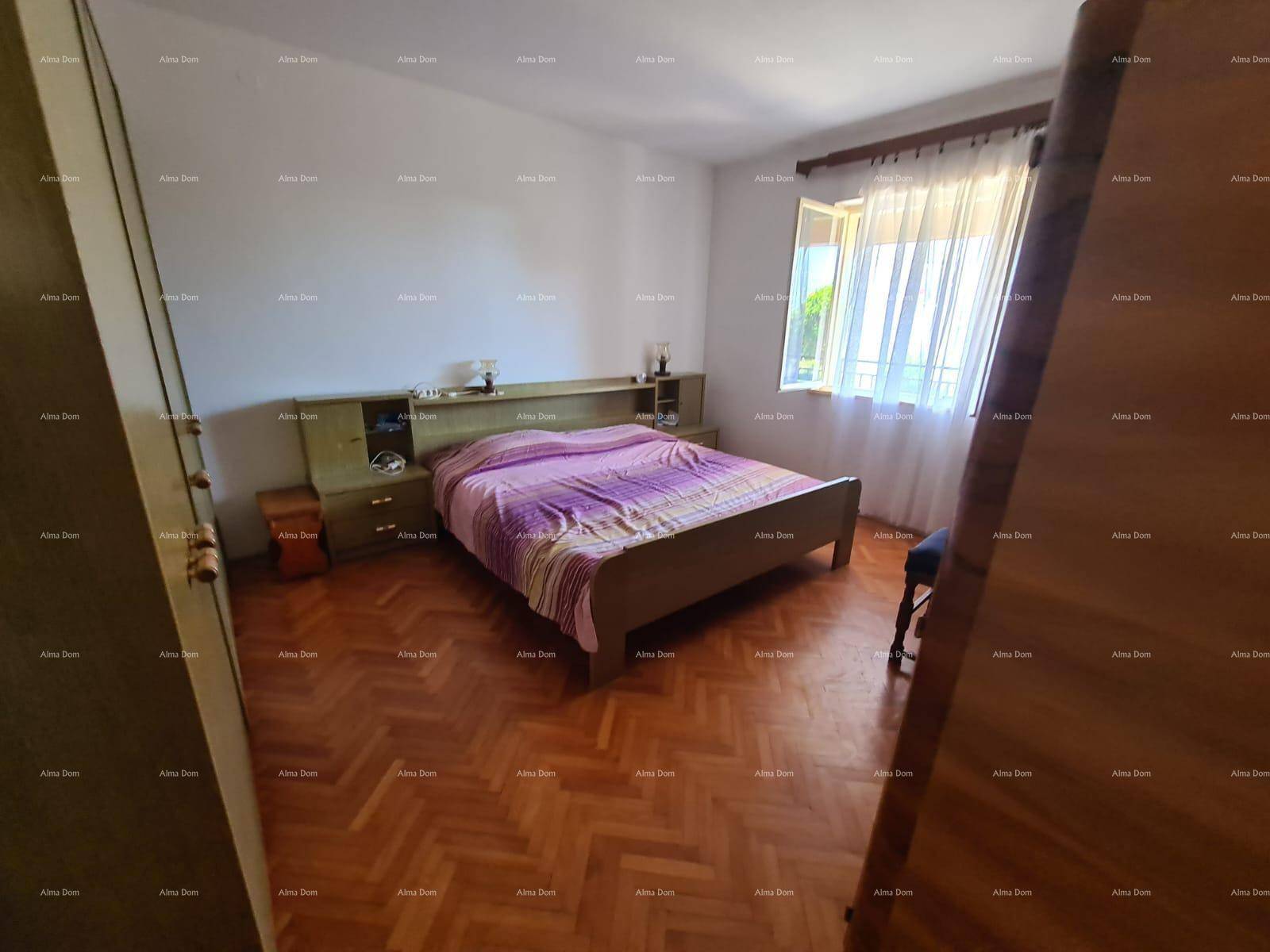 Schlafzimmer mit Doppelbett, Holzparkett und einem großen Kleiderschrank.