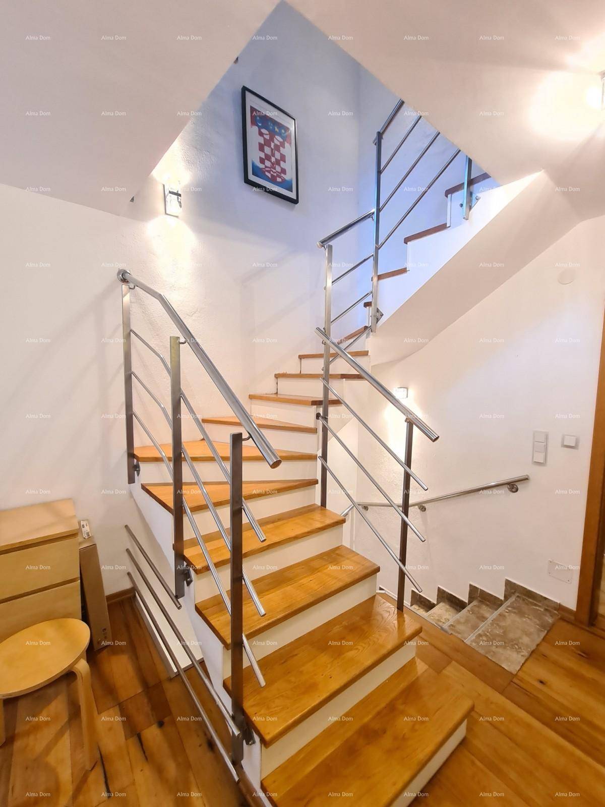 Moderne Treppe mit Holzstufen und elegantem Metallgeländer, verbindet die Etagen.