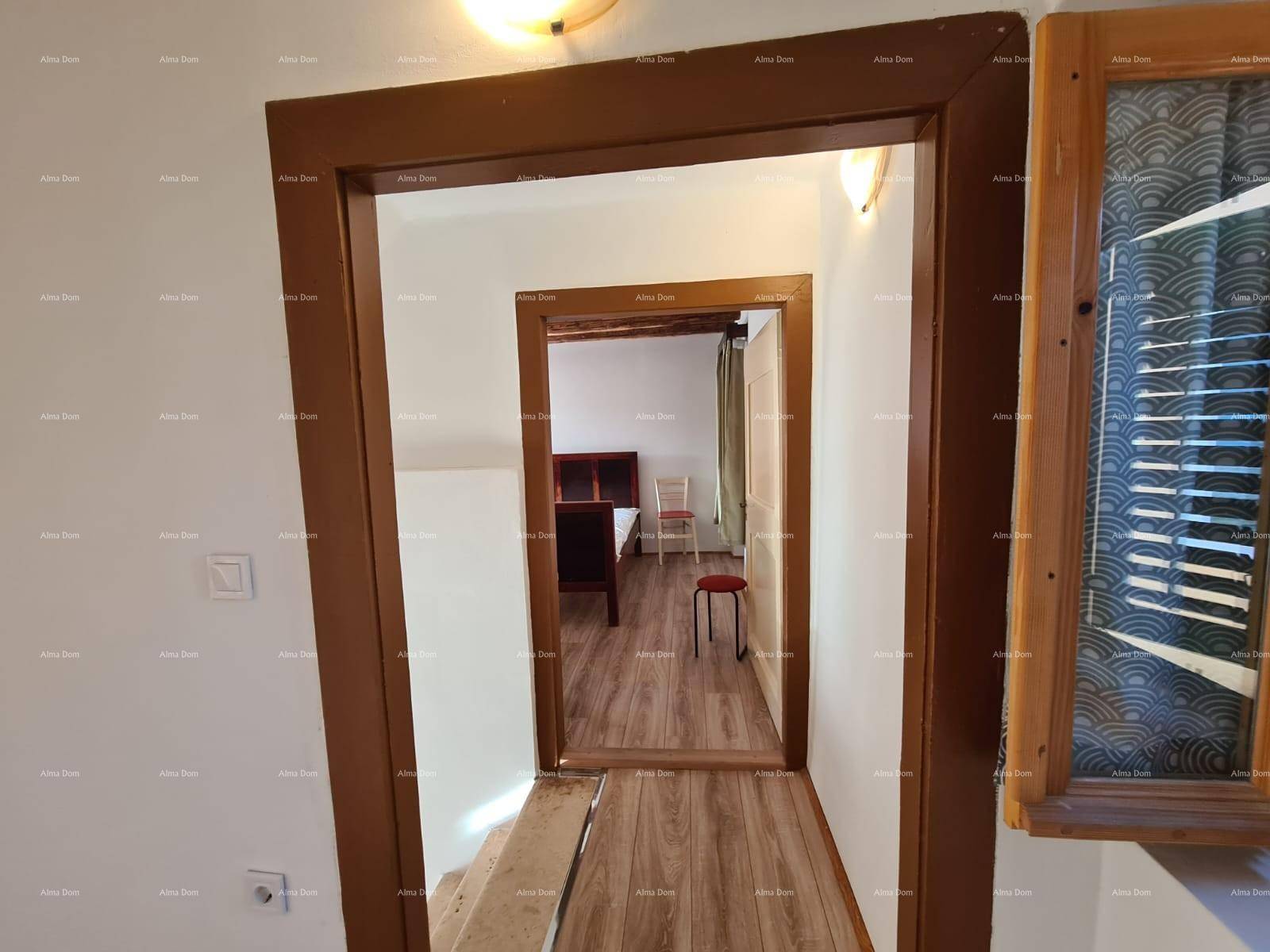 Flur mit Holzboden und Übergang zu einem weiteren Zimmer mit Holzbalkendecke und hellem Ambiente.