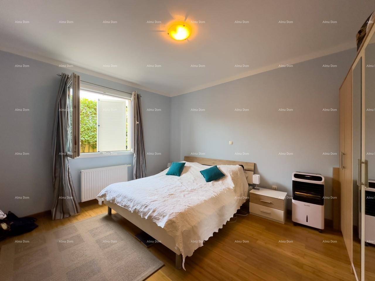 Helles Schlafzimmer mit Holzboden, Doppelbett und Blick ins Grüne durch das Fenster, ruhig gelegen.