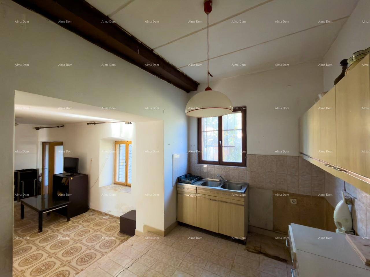 Küche mit Einbauschränken und Blick in den angrenzenden Wohnbereich, mit Holzbalken an der Decke.