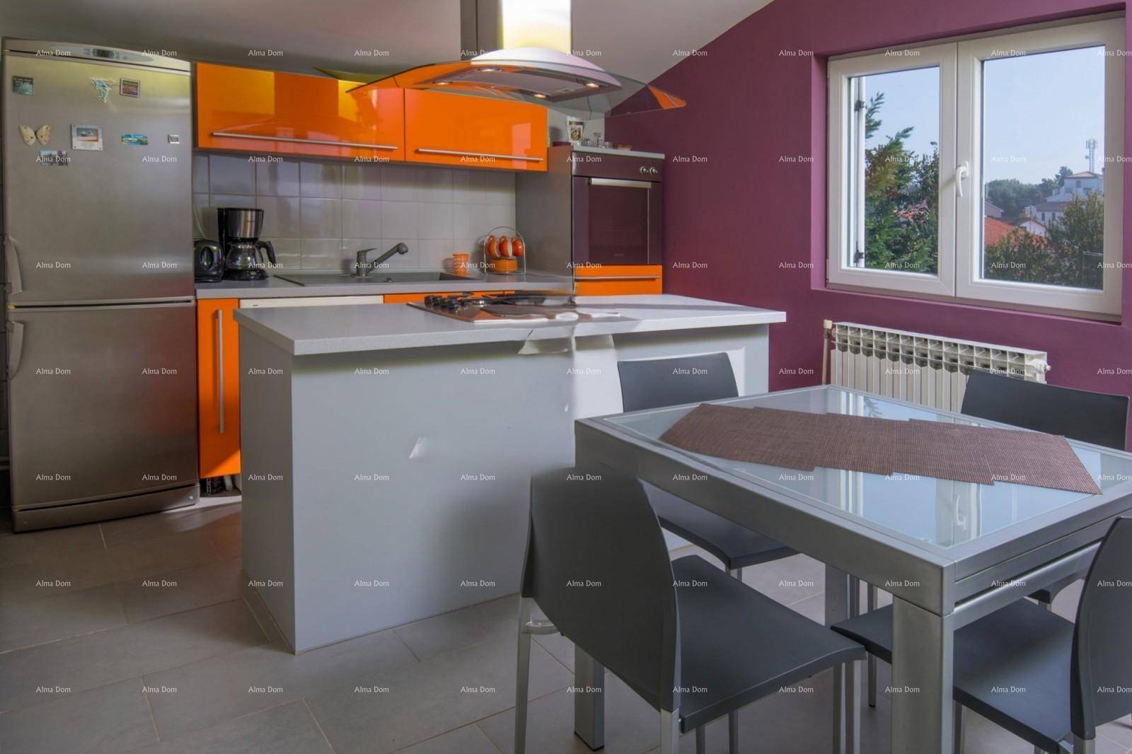 Moderne Küche mit orangefarbenen Schränken, Essbereich und Fenster.