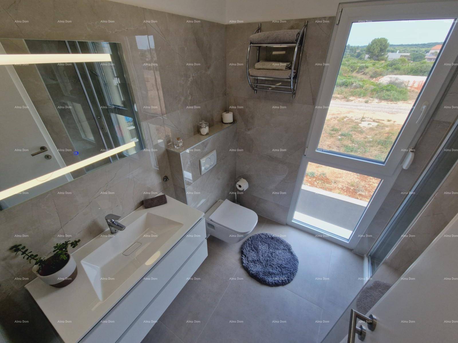 Helles Badezimmer mit modernem Waschtisch, Wand-WC und großem Fenster mit Ausblick.