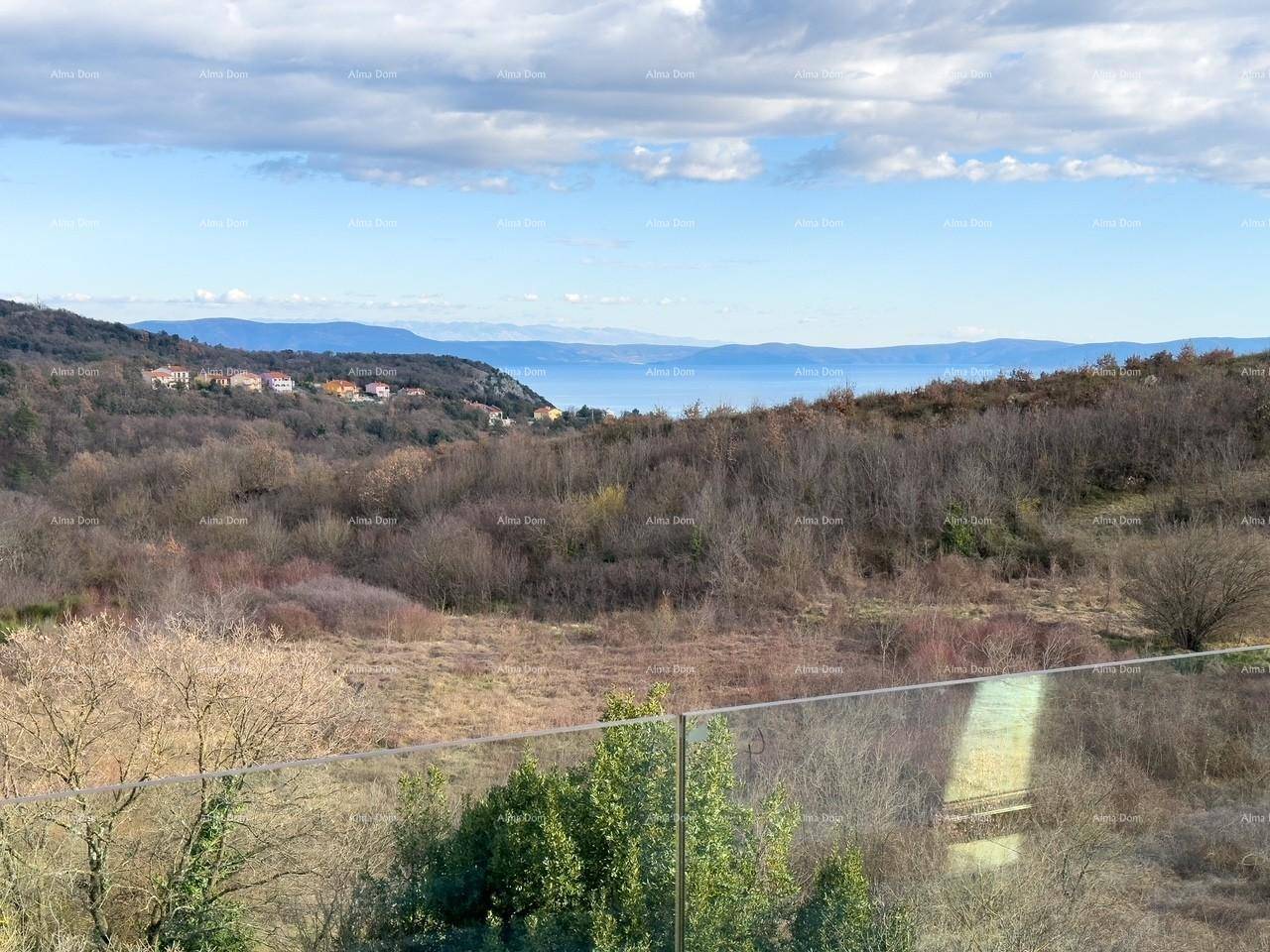 Weitläufiger Ausblick vom Balkon über die grüne Landschaft bis zum Horizont des Meeres.