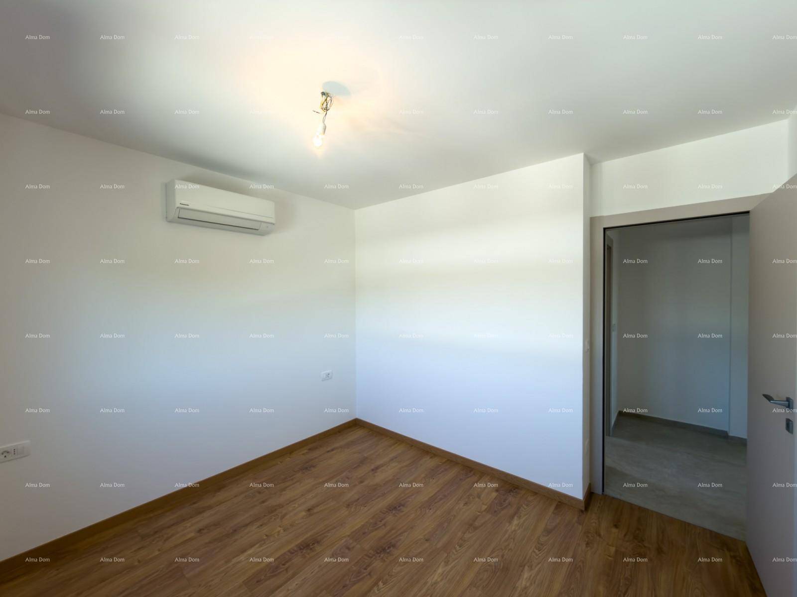 Schlafzimmer mit Holzfußboden, Klimaanlage und weiß gestrichenen Wänden.