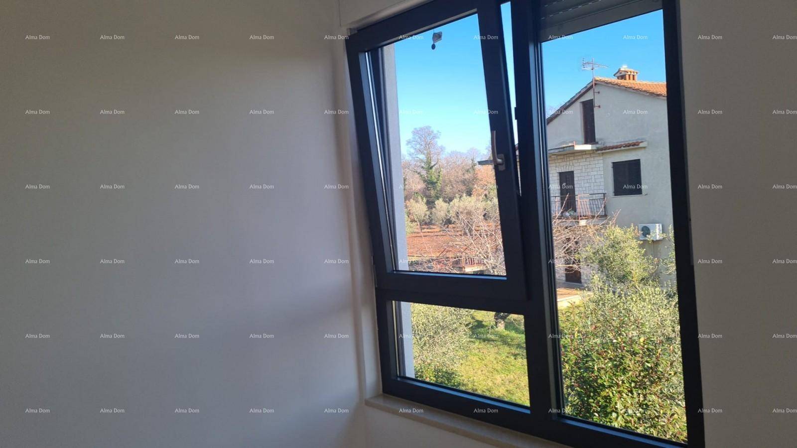 Fenster mit Blick auf grüne Landschaft und ein traditionelles Gebäude.